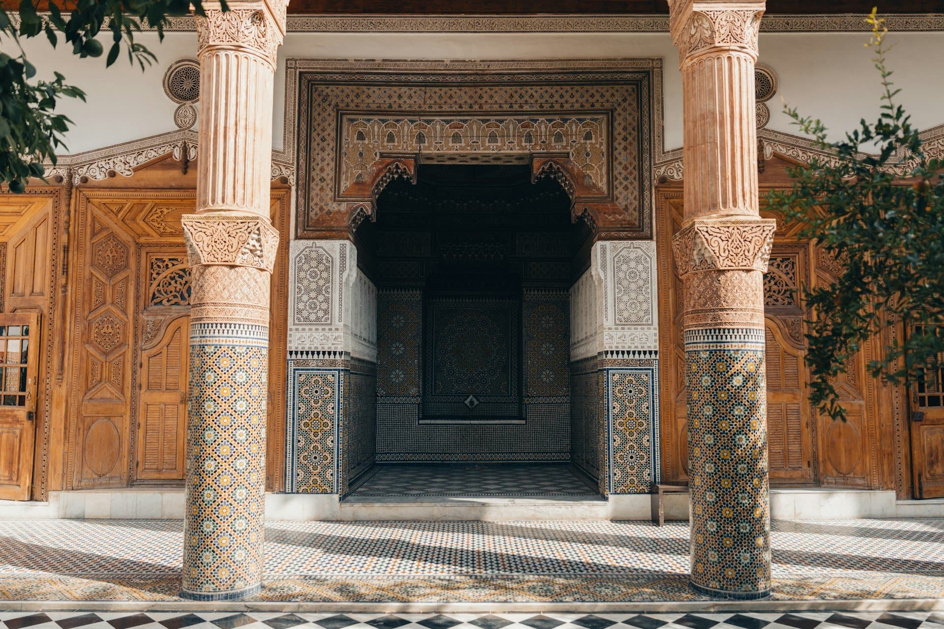 Entrée ornée de zellige et colonnes sculptées d'un riad marocain