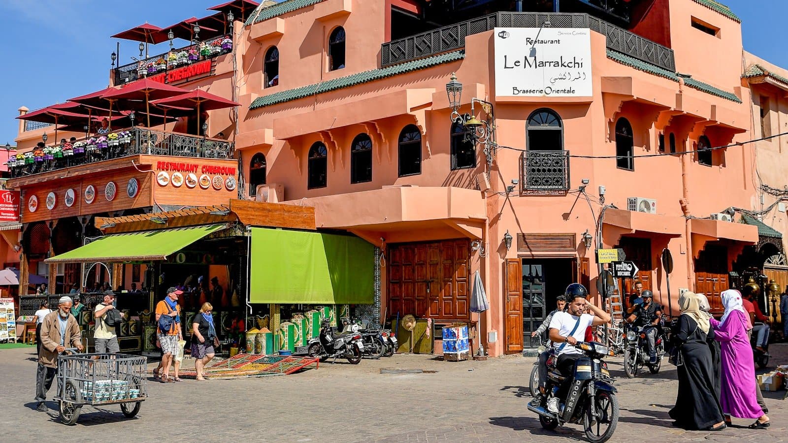Terrasses animées d'un restaurant face à la place à Marrakech en été