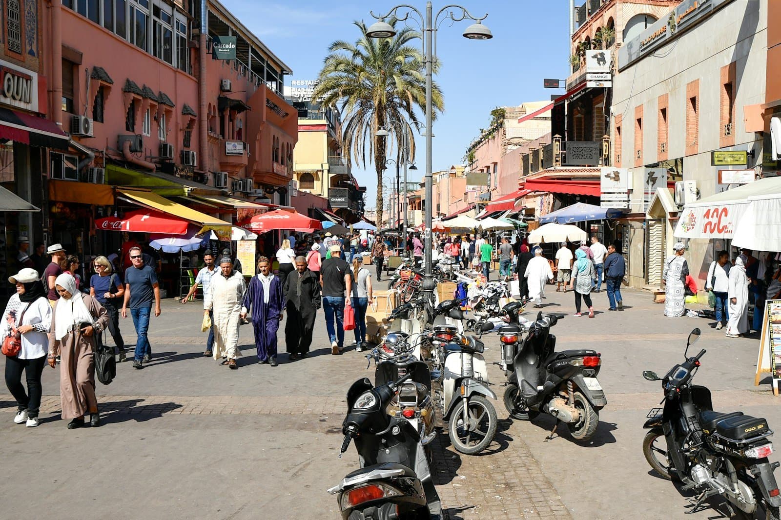 Rue commerçante animée de la médina de Marrakech avec boutiques et passants