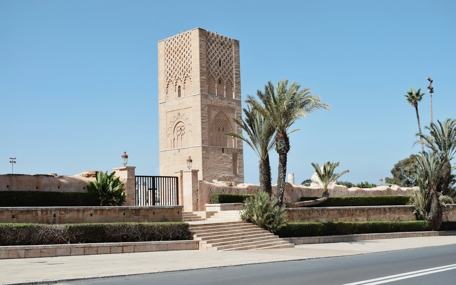 La tour Hassan à Rabat, entourée de palmiers, sous un ciel bleu