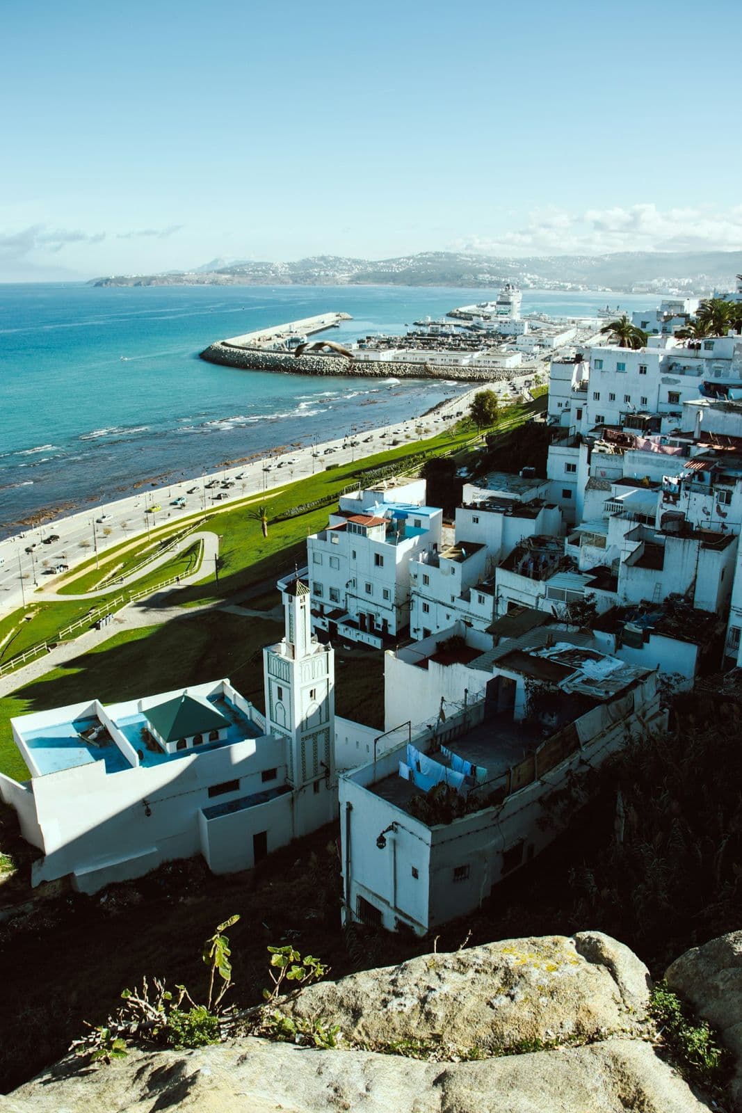 Vue depuis les hauteurs de la Kasbah de Tanger sur les maisons blanches de la médina, un minaret, le port de Tanger Ville et la baie par temps clair