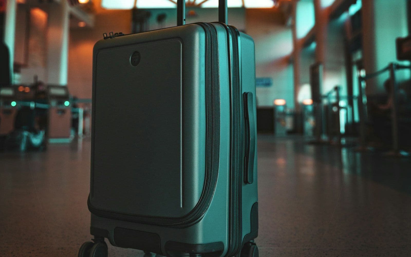 Valise cabine grise posée au sol dans un hall d'aéroport, comptoirs flous à l'arrière-plan (photo d'illustration, pas l'aéroport de Rabat-Salé)