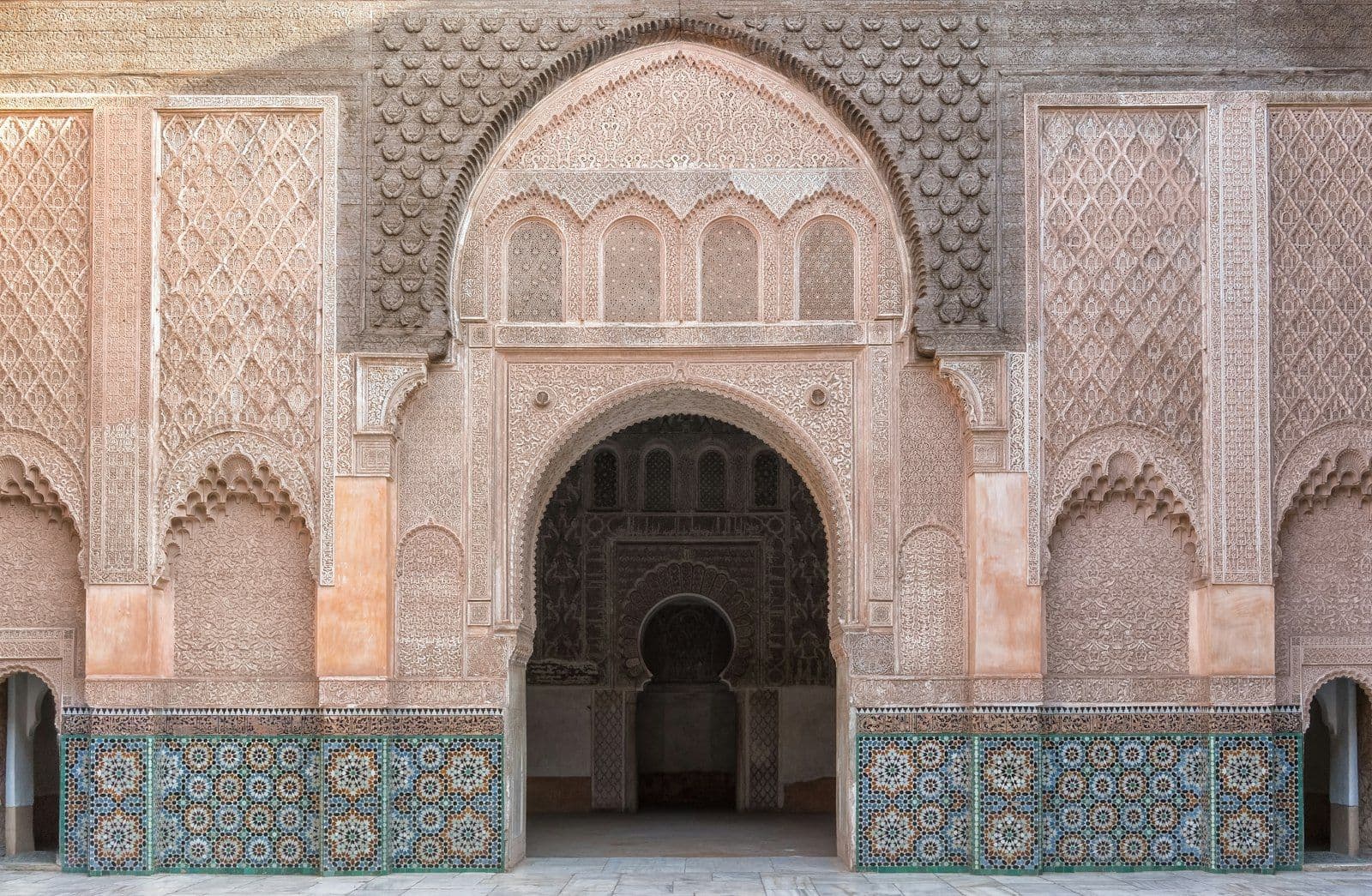 Façade en stuc sculpté et zellige de la cour de la médersa Ben Youssef, à Marrakech